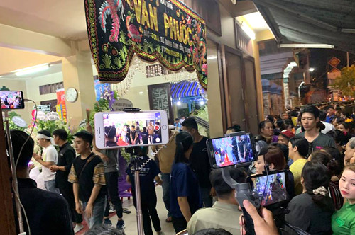 Người làm nội dung YouTube đang "câu view" bất chấp ảnh 2 Người dân chen chúc ghi hình, livestream ở khu vực tang lễ nghệ sĩ Anh Vũ. Ảnh: Bill.
