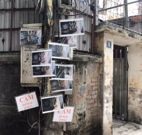 Gần chục bức hình người đổ rác trộm treo trên cây cột điện, khiến nhiều người e ngại không dám đến đổ rác ở đây nữa. Ảnh: Lệnh Thắng.