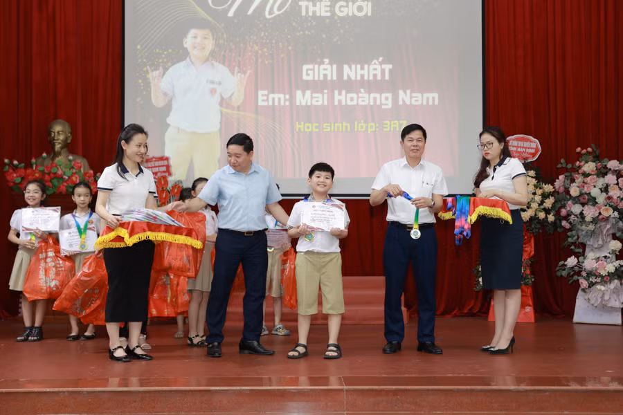 Đại diện ban tổ chức trao thưởng cho học sinh xuất sắc.