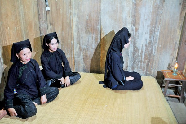 Cô dâu ngồi trước ngọn đèn trước khi ra thưa chuyện và mời trầu... bố mẹ chồng và họ hàng