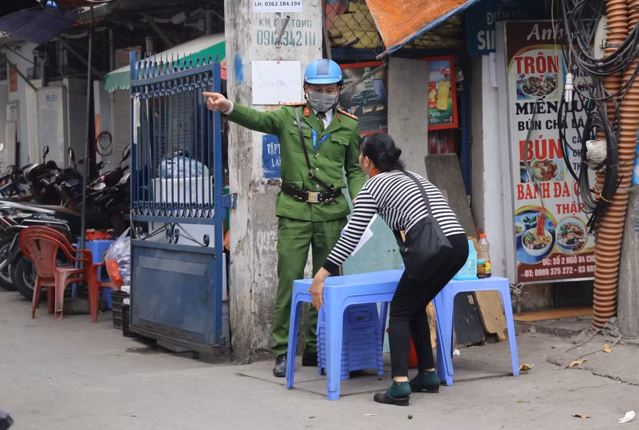 Lực lượng chức năng nhắc nhở, yêu cầu người dân không được lấn chiếm vỉa hè để bán hàng tại ngõ 84 phố Chùa Láng.