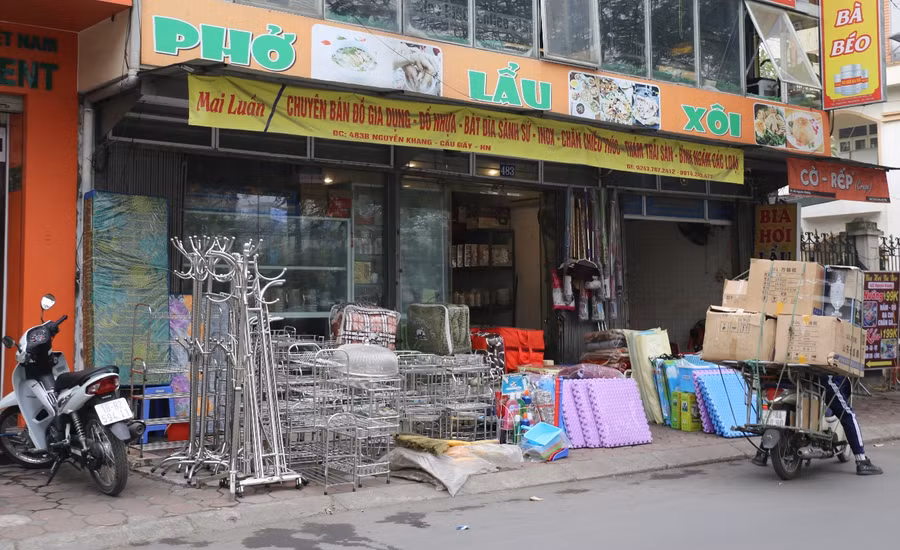 Một hàng tạp hóa trên phố Nguyễn Khang bày bán chiếm dụng hết vỉa hè.