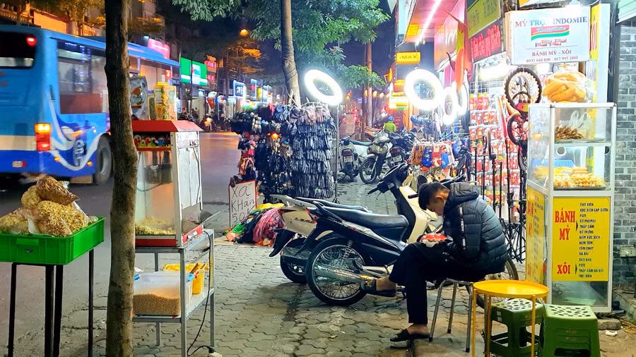 Theo các chuyên gia, tình trạng lấn chiếm vỉa hè trên địa bàn thành phố Hà Nội đang diễn ra tràn lan với nhiều mục đích khác nhau. Trong đó chủ yếu người dân sử dụng vỉa hè làm chỗ để phương tiện, kinh doanh hàng quán, làm chỗ để vật liệu xây dựng, hình thành chợ cóc, bán hàng rong lề đường. (Trong ảnh: Vi phạm lấn chiếm vải hè tại số nhà 161 phố Khâm Thiên.