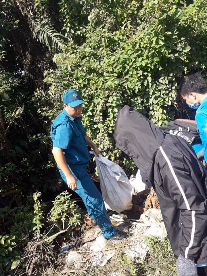 Anh Lê Hiếu Lành cùng lực lượng dân quân dọn rác tại kênh thoát nước đường lã Xuân Oai.
