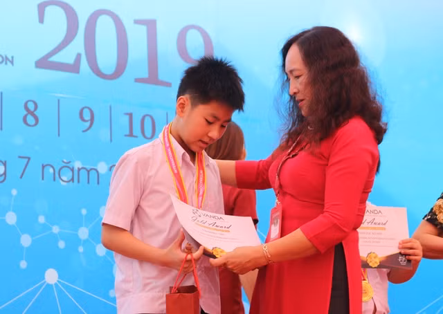 Đại diện Trường iSchool Hà Tĩnh trao giải Huy chương Vàng cho thí sinh.