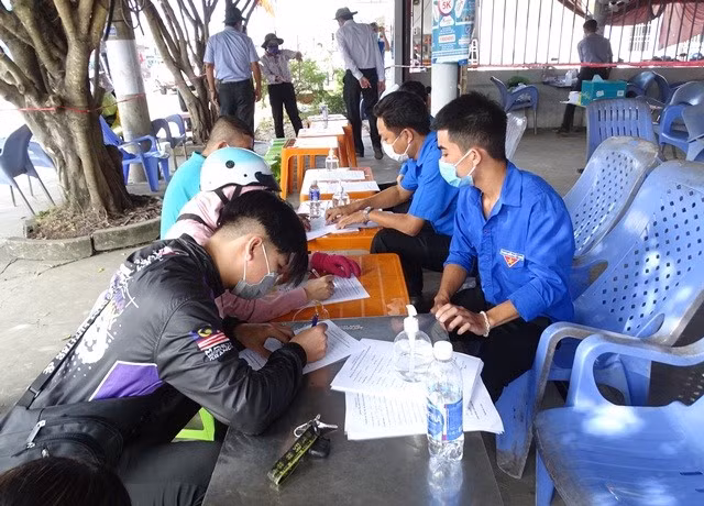 Người dân được hướng dẫn khai báo y tế tại chốt kiểm soát dịch Covid-19 tuyến Quốc lộ 1 (ảnh Cổng TTĐT Cà Mau).