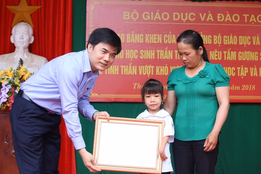 Thừa ủy quyền của Bộ trưởng Phùng Xuân Nhạ, ông Bùi Văn Linh - Phó vụ trưởng Phụ trách Vụ Giáo dục Chính trị và Công tác học sinh, sinh viên tặng Bằng khen cho em Trần Thị Hoa