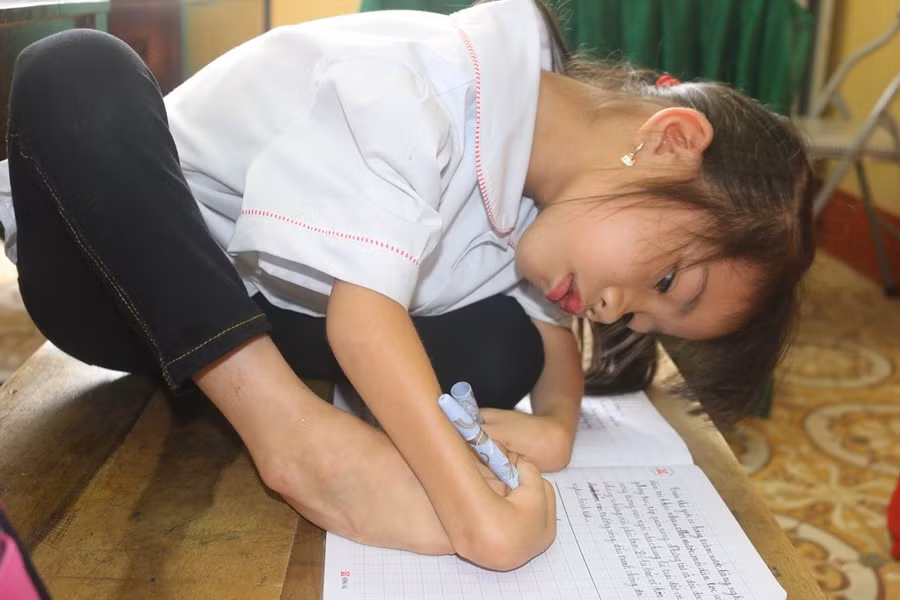 Em Trần Thị Hoa viết bằng cả tay kết hợp với chân