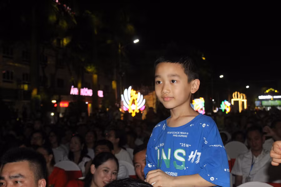 Một em nhỏ được gia đình đưa đi xem lễ hội nhân ngày nghỉ lễ. Ảnh: LT.