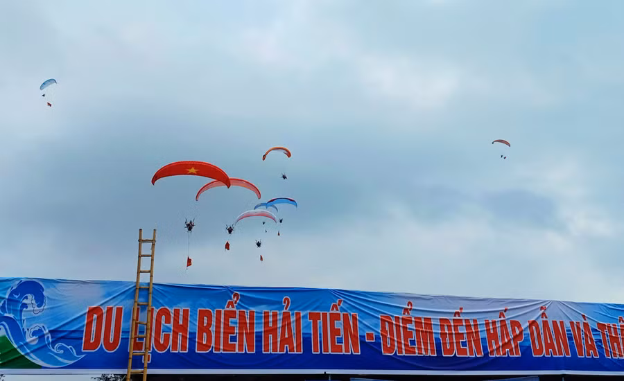 Đặc biệt, những chiếc dù lượn mang màu sắc rực rỡ, in hình của quốc kỳ Việt Nam tung bay trong gió, tạo nên điểm nhấn cho mùa du lịch biển Hải Tiến năm nay. Ảnh: LT.