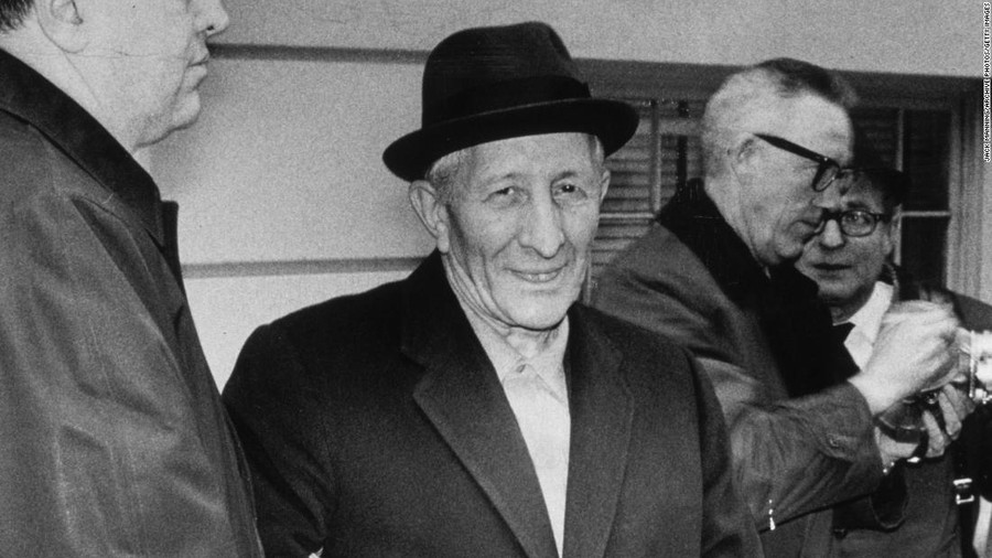 Ông trùm Carlo Gambino mỉm cười trước ống kính, dù vừa bị FBI còng tay