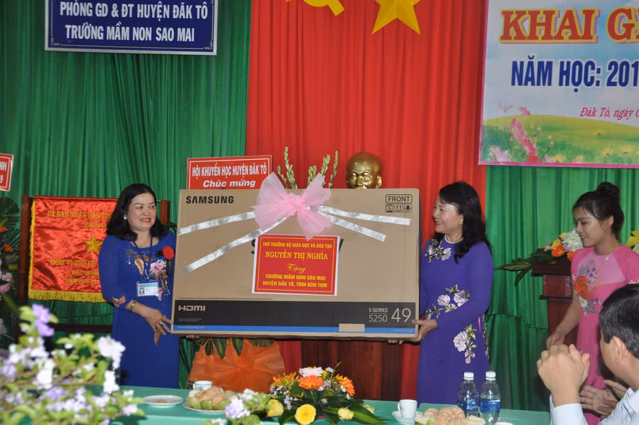 Thứ trưởng Nguyễn Thị Nghĩa trao tặng quà cho học sinh và tập thể nhà trường.