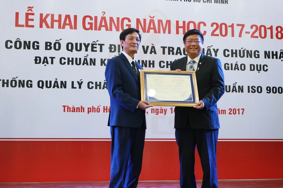 Thạc sĩ Lâm Văn Quản- Hiệu trưởng nhà trường (trái) đón nhận giấy chứng nhận đạt chuẩn kiểm định