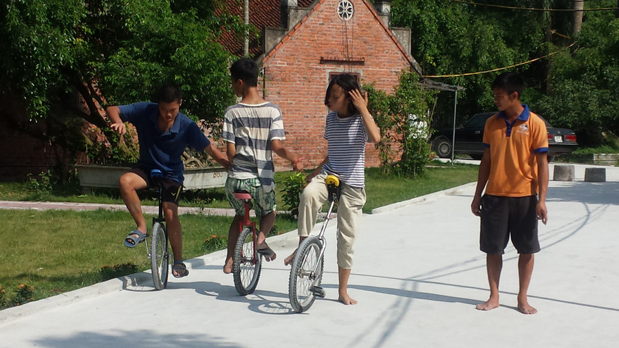 Các em tự kỷ đang kiên nhẫn dạy cho nhau kỹ năng đi xe đạp một bánh Các em tự kỷ đang kiên nhẫn dạy cho nhau kỹ năng đi xe đạp một bánh