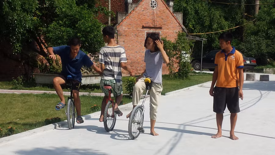 Các em tự kỷ đang kiên nhẫn dạy cho nhau kỹ năng đi xe đạp một bánh