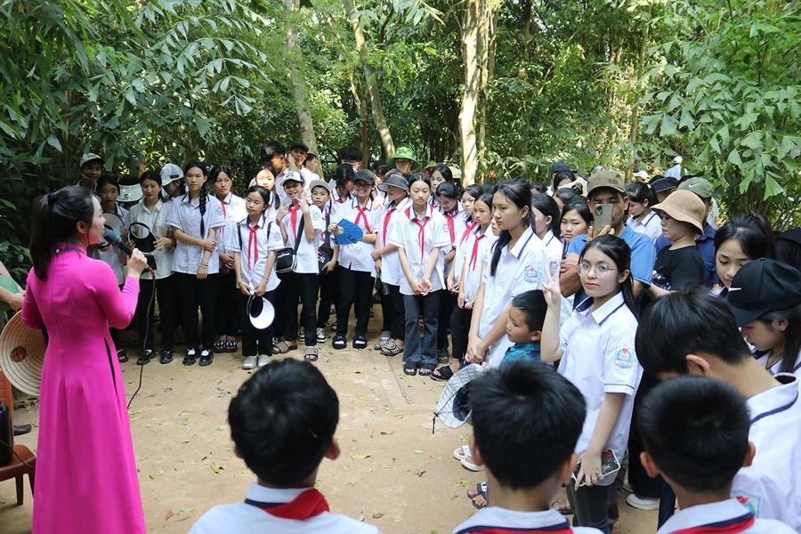 Học sinh nghe thuyết minh tại Khu di tích Kim Liên. 