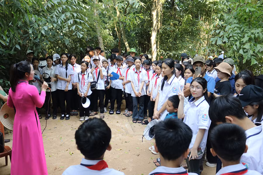 Học sinh nghe thuyết minh tại Khu di tích Kim Liên. 