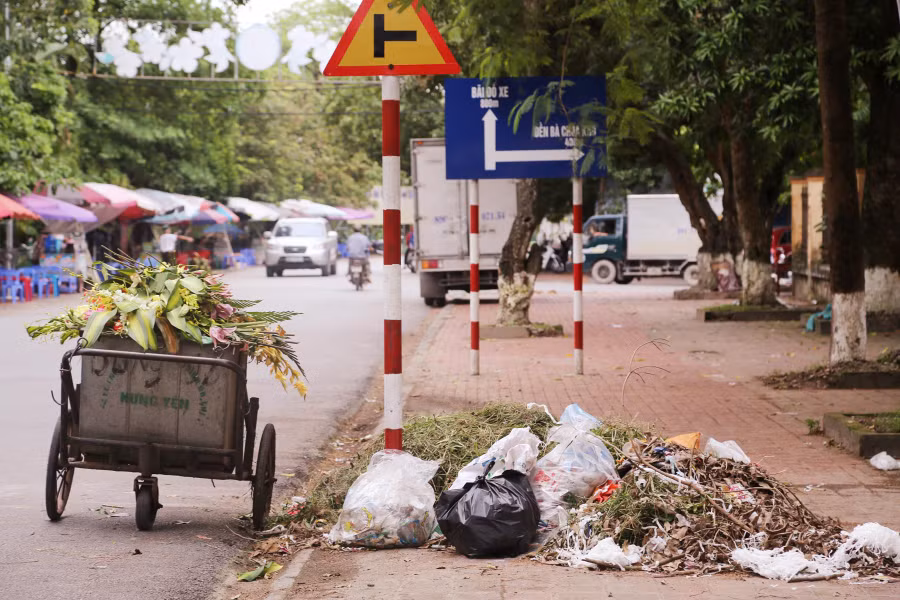 Rác ùn ứ trên vỉa hè và xe gom rác đậu dưới lòng đường