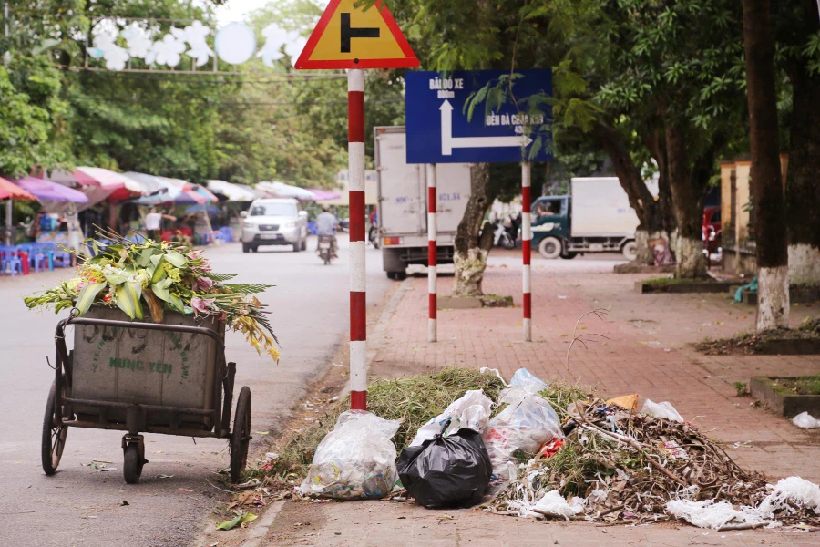 Rác ùn ứ trên vỉa hè và xe gom rác đậu dưới lòng đường