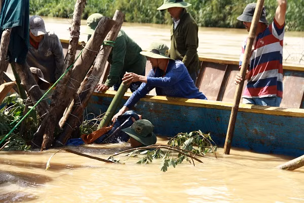 Nguy cơ đê bị vỡ nên hàng trăm người dân thức trắng đêm đầm mình trong nước để gia cố, sửa chữa. Ảnh: Trúc Hân