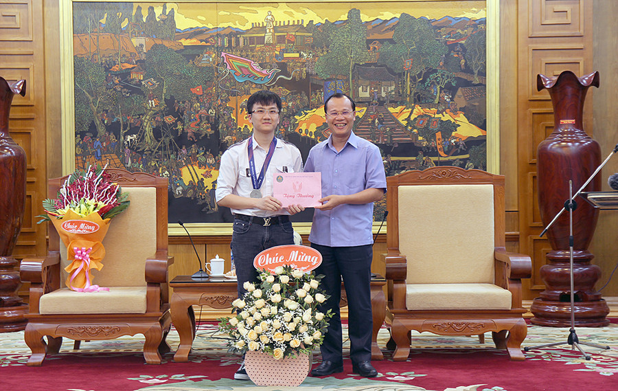 Đồng chí Mai Sơn, Chủ tịch UBND Thành phố Bắc Giang chúc mừng và trao thưởng cho em Trịnh Duy Hiếu.