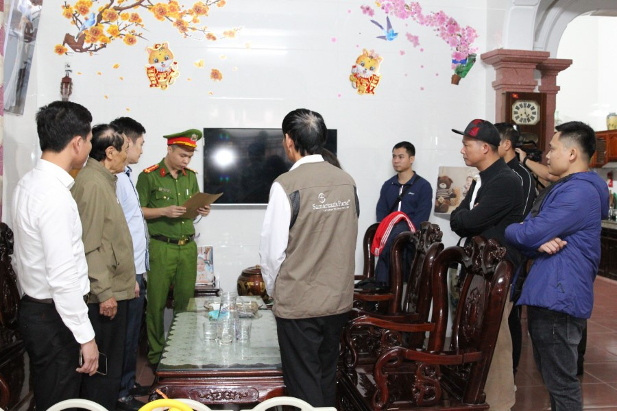 Lực lượng chức năng đọc lệnh khám xét nhà Nguyễn Tuấn Anh. (Ảnh: CANA)