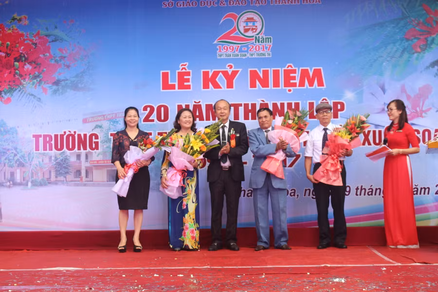 Ông Đào Ngọc Quyền – Chủ tịch HĐQT Trường THPT Trường Thi - trao hoa tri ân cựu giáo viên nhà trường. Ảnh: Nguyễn Quỳnh