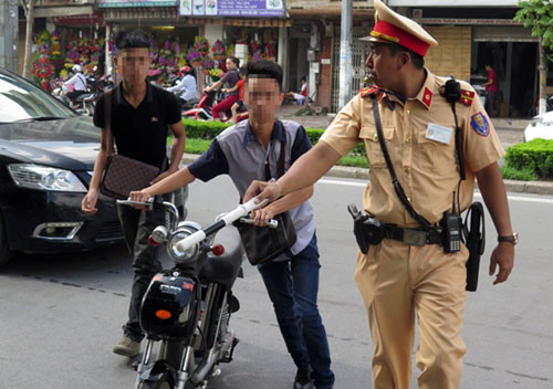 Cảnh sát giao thông Hà Nội thường xuyên xử lý nhiều học sinh đi xe đạp điện, xe máy không đội mũ bảo hiểm. Ảnh: Sơn Tuân
