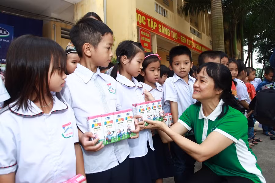 Bà Nguyễn Minh Tâm – Giám đốc Chi nhánh Vinamilk tại Hà Nội trao quà cho các em học sinh.