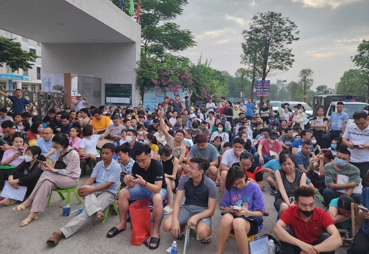 Rất đông phụ huynh ngồi chờ ở cổng trường để nộp hồ sơ cho con từ đêm 12/6 đến sáng 13/6.