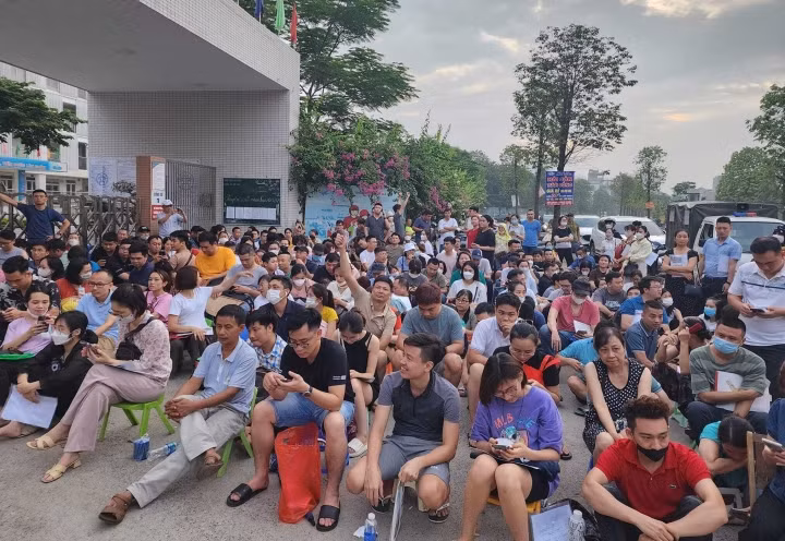 Rất đông phụ huynh ngồi chờ ở cổng trường để nộp hồ sơ cho con từ đêm 12/6 đến sáng 13/6.