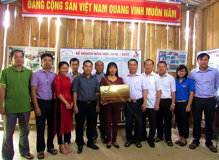 GS.TS Phạm Hồng Quang trao tặng tấm biển sẽ được gắn lên công trình vừa hoàn thành cho cô Trần Thị Kim Khuyên. 