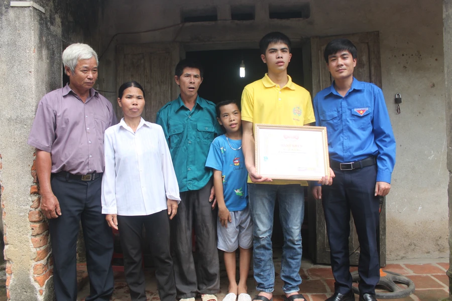 Anh Lê Văn Châu - phó bí thư Tỉnh đoàn Thanh Hóa (bìa phải) tặng bằng khen cho em Lê Hữu Hiếu sáng 9/7. 