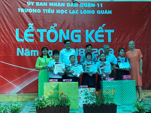 Cô Nguyễn Thị Kim Hương(bên trái) trao bằng khen và phần thưởng cho nhóm học sinh đã giành giải cao trong cuộc thi First Lego League 2019 diễn ra tại Mỹ vừa qua