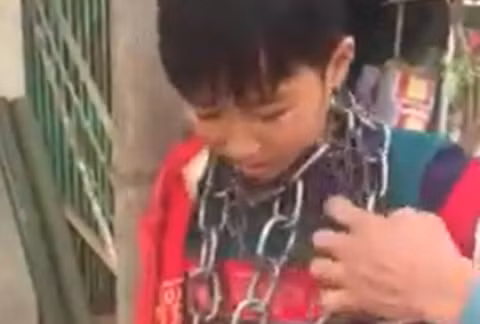  Bé L.B.N bị người thân quấn xích quanh cổ. Ảnh cắt từ clip 