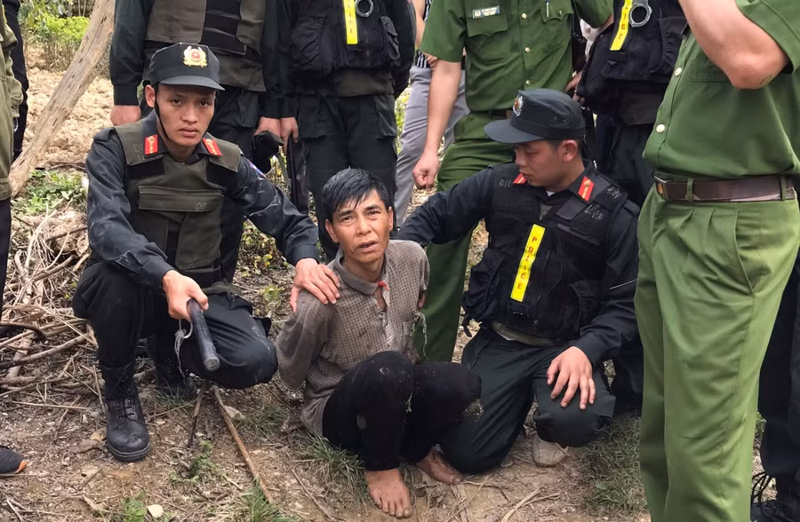 Đối tượng Đầm Văn Xuân (ở giữa) bị bắt giữ khi đang trên đường lẩn trốn trong rừng