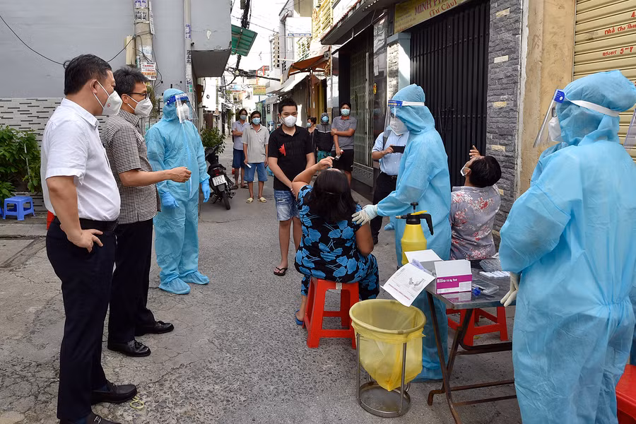 Phó Thủ tướng Vũ Đức Đam đề nghị đội lấy mẫu từ Trường Đại học Y Thái Bình hướng dẫn người dân ở Hẻm 83, đường Bông Sao (Quận 8) tự lấy mẫu xét nghiệm nhanh. Ảnh: VGP/Đình Nam.