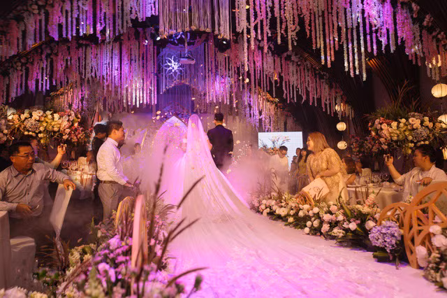 Tại buổi tiệc ballroom, hàng nghìn đoá hoa trải sắc từ hồng nhẹ đến trắng đã được đính kết, trang trí dạng thả rơi trong toàn không gian sảnh tiệc.