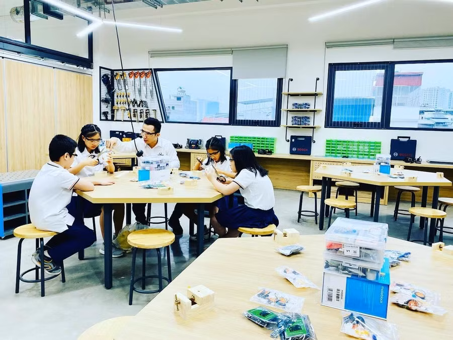 Thầy Phạm Việt Dũng, giáo viên Vật lí và chủ nhiệm MakerSpace, cùng một nhóm các bạn học sinh trong giờ thực hành STEM