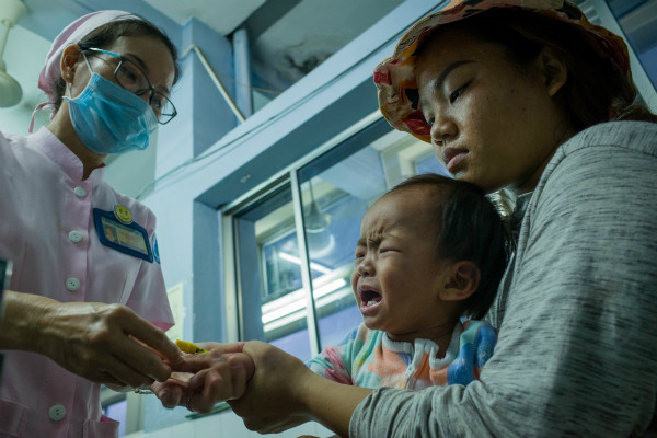 Điều dưỡng khám và đo nhiệt độ cho bé Thảo My, chẩn đoán mắc bệnh sởi phải nhập viện. Tâm sự của những người mẹ trắng đêm cùng con chiến đấu mùa dịch