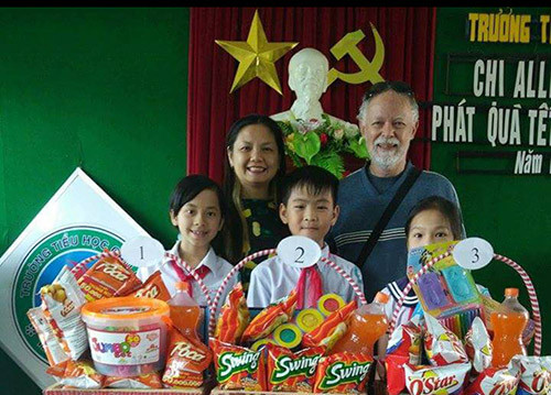 Vợ chồng bà Lan trong trong một lần phát quà cho học sinh. Bà Lan và ôngông Roy Ẻrle Hornsby trong một lần phát quà tết cho học sinh. Ảnh: Nhân vật cung cấp.