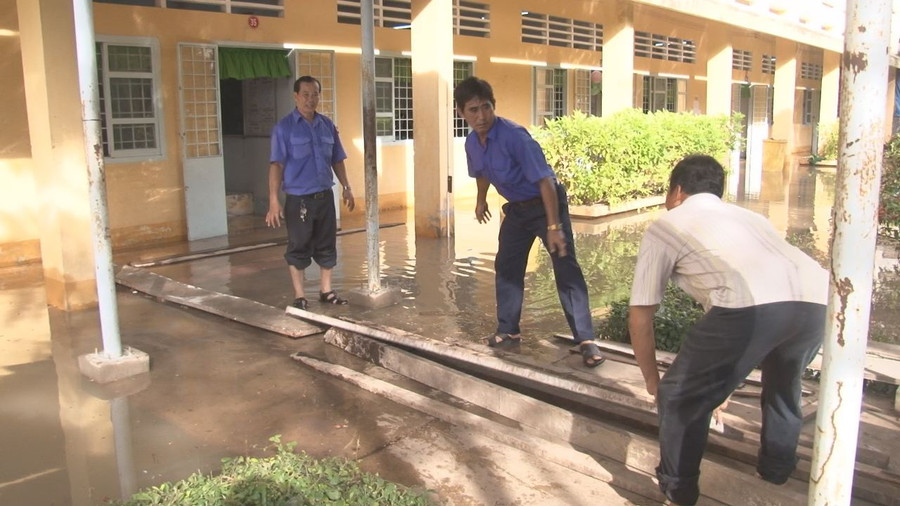 Giáo viên và học sinh phải đi lại trên những tấm ván lót tạm