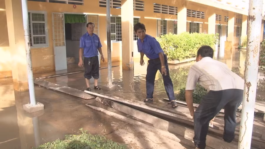 Giáo viên và học sinh phải đi lại trên những tấm ván lót tạm