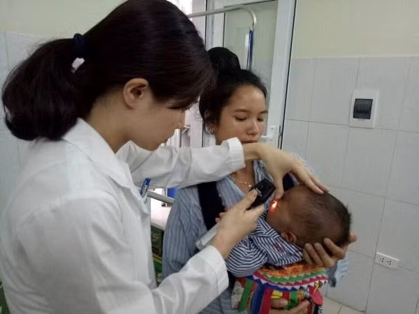 Bác sĩ khám mắt cho bệnh nhi. Bác sĩ khám mắt cho bệnh nhi.