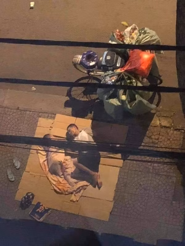  Trong khi người người, nhà nhà đang đi sắm tết, quây quần bên bữa ăn gia đình ấm cúng, thì ở 1 góc phố vẫn có 2 bố con ngày đi gom ve chai tối ngủ vỉa hè. Với bố con người đàn ông này thì bìa giấy chính là đệm, tấm vải mỏng là chăn, sau 1 ngày dài gom, lượm, 2 bố con anh ngủ cạnh chiếc xe đầy ve chai của mình.