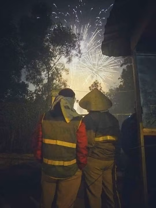  Làm việc nhưng vẫn tranh thủ ngắm nhìn khoảnh khắc năm cũ bước qua năm mới tới đó chính là những người lao công thầm lặng. Bất kể đem ngày, họ giữ cho đường phố luôn sạch đẹp.