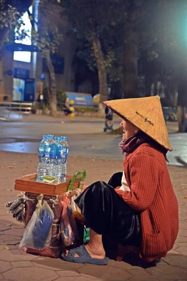  Đêm 30 tết, người đi chơi, người quây quần bên mâm cơm đoàn viên nhưng bà vẫn lặng lẽ ngồi ở ven đường bán những món đồ lặt vặt. Hình ảnh bà cụ lẻ loi một mình khiến nhiều người không khỏi xót xa.