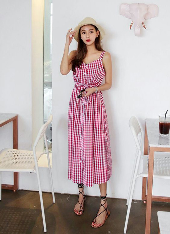 Dáng váy hai dây quen thuộc được làm mới bằng cách bố trí hàng nút và dây dưng lại trang trí cho eo thon.