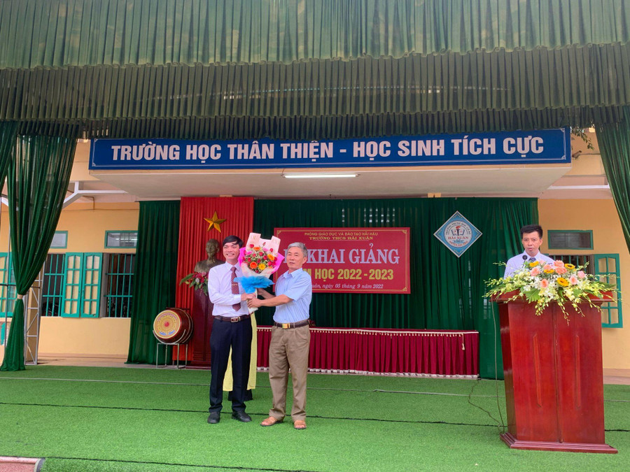 Thầy Phạm Văn Trang (bìa trái) nhận hoa chúc mừng năm học mới từ đại biểu khách mời trong lễ khai giảng. Thầy Phạm Văn Trang (bìa trái) nhận hoa chúc mừng năm học mới từ đại biểu khách mời trong lễ khai giảng.