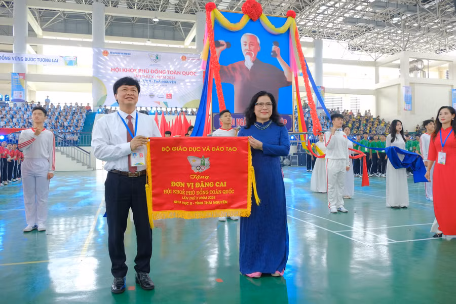 Bà Nguyễn Thị Kim Chi - Thứ trưởng Bộ GD&ĐT tặng Cờ lưu niệm cho đơn vị đăng cai tỉnh Thái Nguyên.